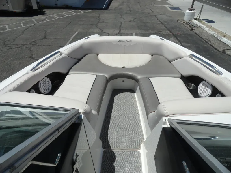Slide: The Image of 2006 MasterCraft X-45 boat interior with gray and white seating, speakers, and cup holders. - 20