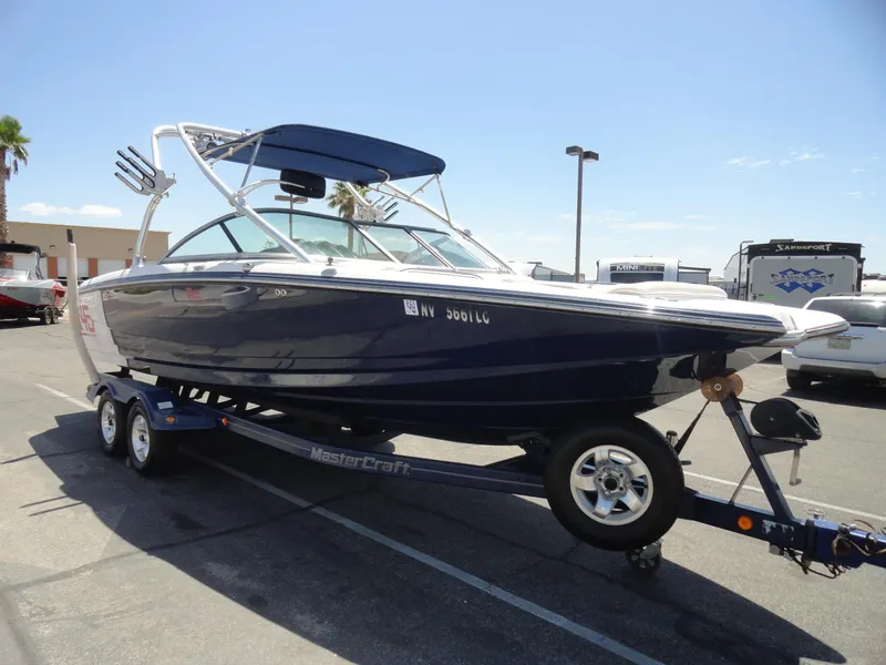 Slide: The Image of 2006 MasterCraft X-45 boat on trailer in parking lot, blue and white design. - 4