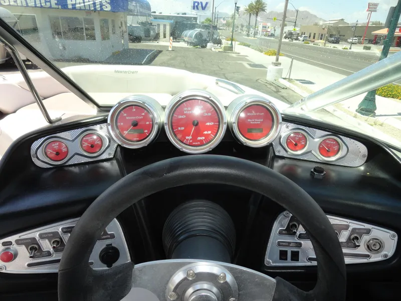 Slide: The Image of 2006 MasterCraft X-45 boat dashboard with red gauges and steering wheel. - 9