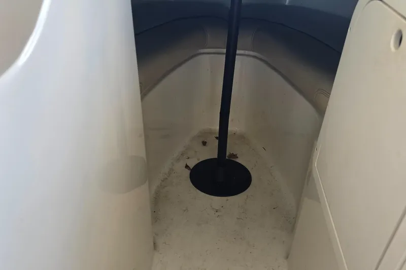 Slide: The Image of Interior of a 1998 Sea Ray 210br boat, showing storage compartment with a pole. - 12