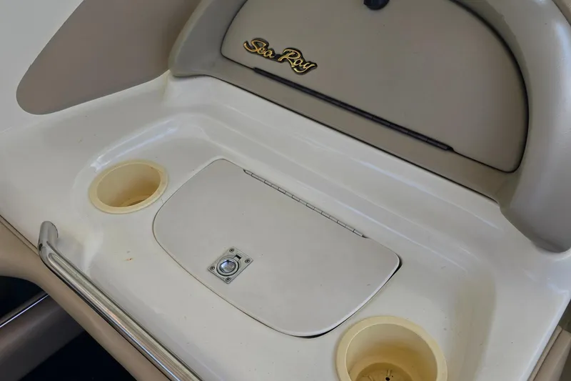Slide: The Image of 1998 Sea Ray 210br boat interior with storage compartment and cup holders. - 7