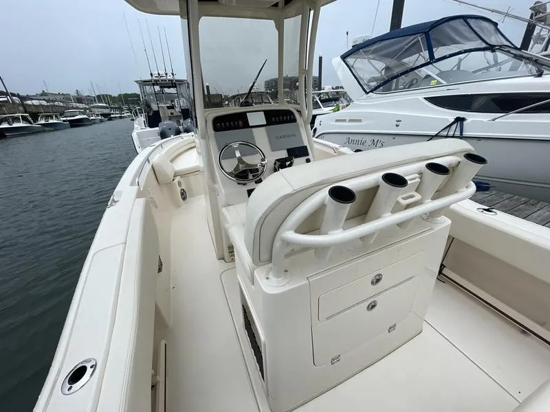 Slide: The Image of 2026 Grady-White 257 Fisherman boat interior at marina, featuring helm and rod holders. - 8