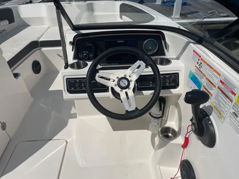 Slide: The Image of 2023 Bayliner DX 2200 boat cockpit with steering wheel and control panel. - 10