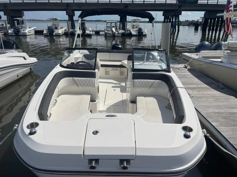 Slide: The Image of 2023 Bayliner DX 2200 boat docked, featuring spacious seating and sleek design. - 3