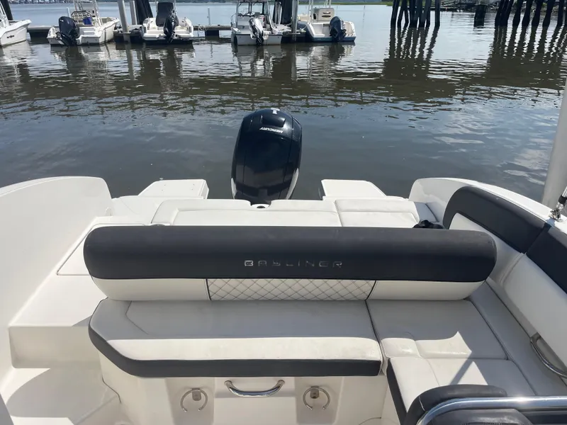 Slide: The Image of 2023 Bayliner DX 2200 boat interior with seating, docked at marina. - 6