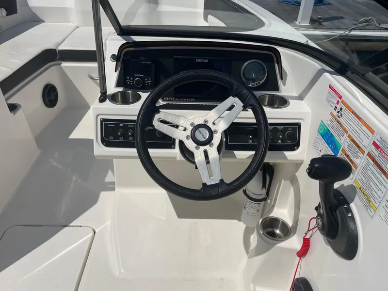 Slide: The Image of 2023 Bayliner DX 2200 boat dashboard with steering wheel and control panel. - 8