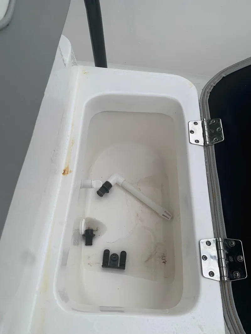 Slide: The Image of Open storage compartment with fittings in a 2015 Key Largo 180 Center Console boat. - 11