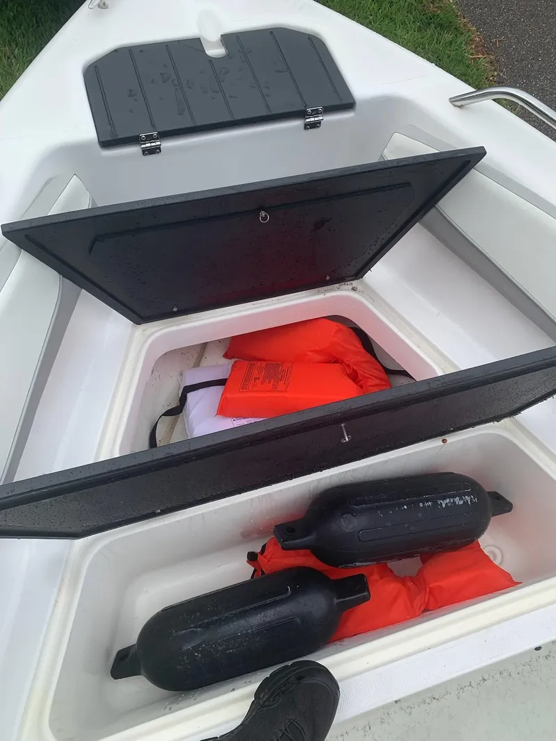 Slide: The Image of Open storage compartment on 2015 Key Largo 180 Center Console with life jackets and fenders. - 15
