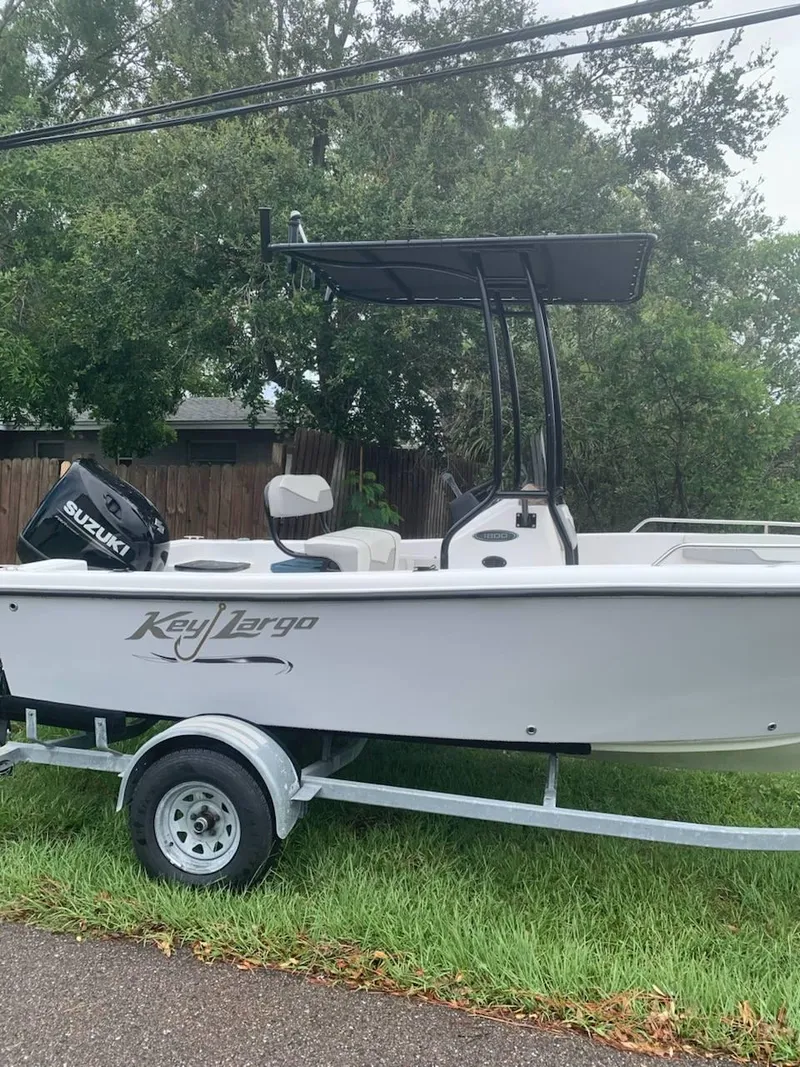 Slide: The Image of 2015 Key Largo 180 Center Console boat on trailer, parked on grass. - 17