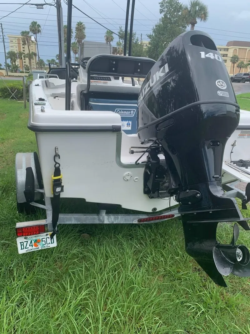 Slide: The Image of 2015 Key Largo 180 Center Console boat with Suzuki 140 outboard motor on grassy area. - 20