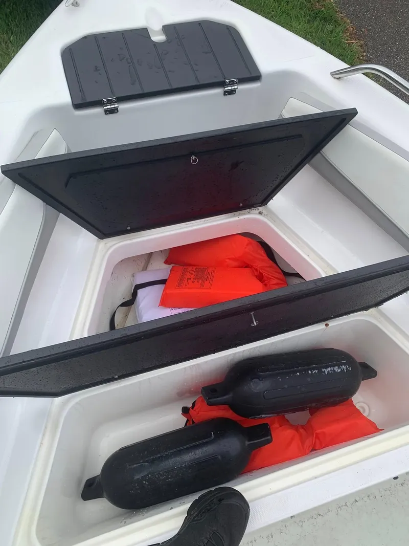 Slide: The Image of Open storage compartment on 2015 Key Largo 180 Center Console with life jackets and fenders. - 22