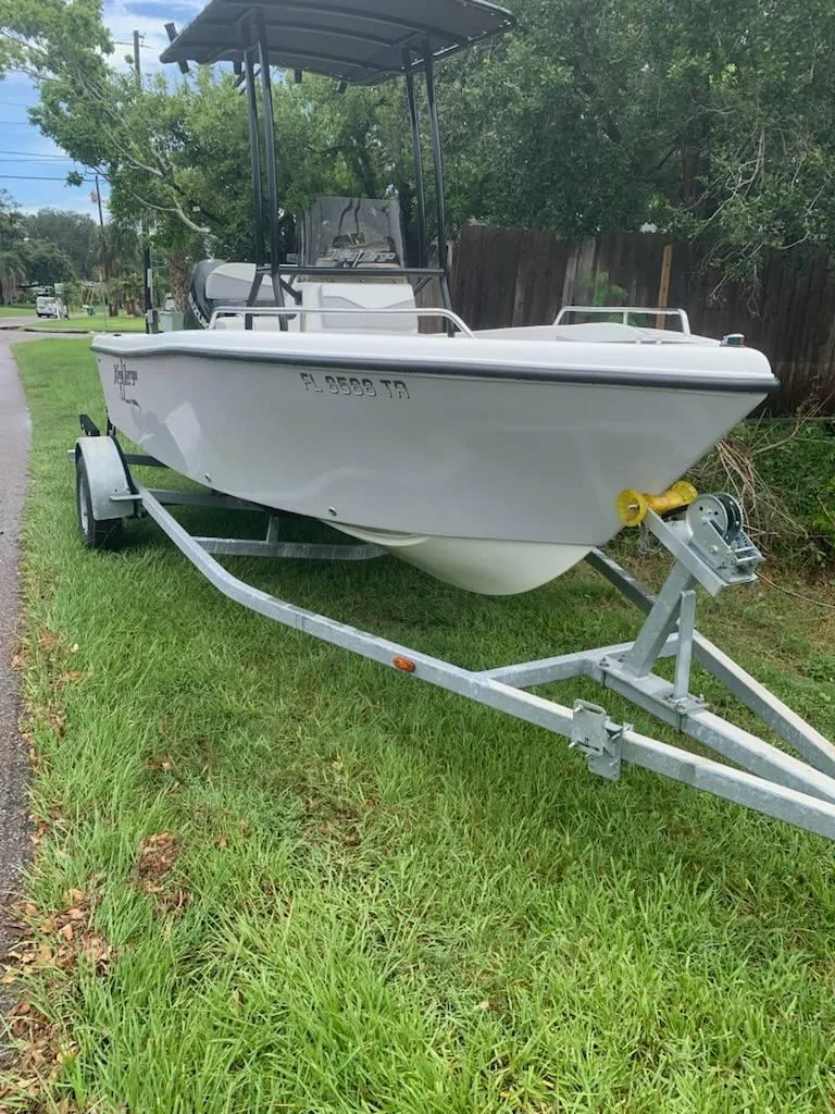Slide: The Image of 2015 Key Largo 180 Center Console boat on trailer, parked on grass. - 23