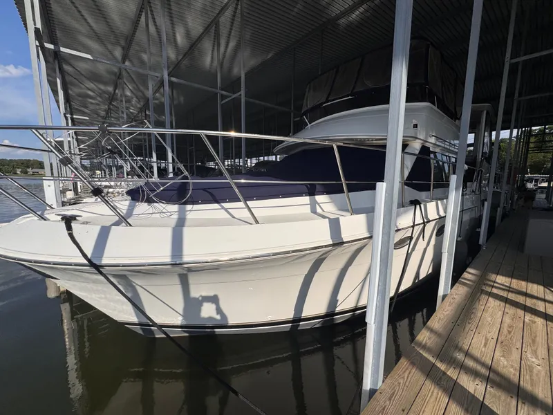 Slide: The Image of 1998 Carver 405 Aft Cabin yacht docked under covered marina. - 0