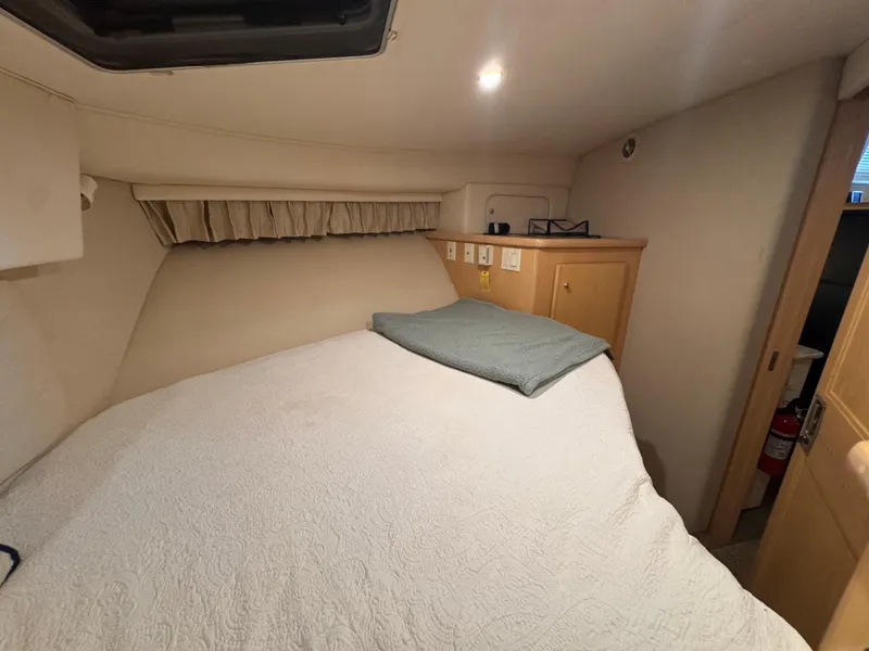 Slide: The Image of 1998 Carver 405 Aft Cabin interior with cozy bed and wooden cabinetry. - 10