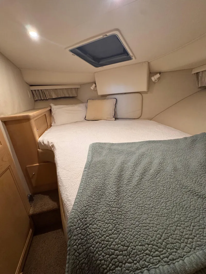 Slide: The Image of 1998 Carver 405 Aft Cabin interior with cozy bed, soft lighting, and elegant decor. - 11