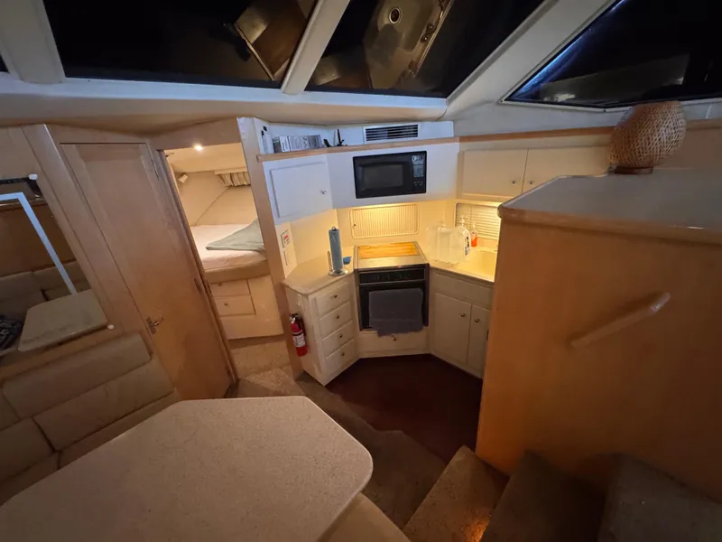 Slide: The Image of 1998 Carver 405 Aft Cabin interior with kitchen, microwave, and cozy sleeping area. - 14