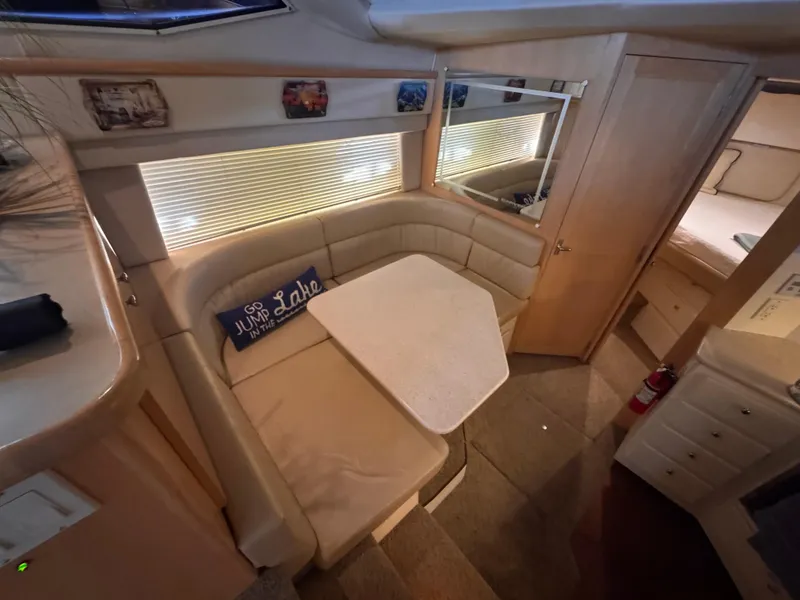 Slide: The Image of 1998 Carver 405 Aft Cabin interior with cozy dining area and decorative pillow. - 15