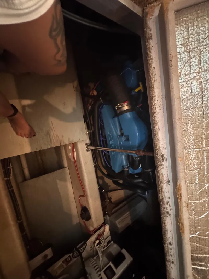 Slide: The Image of Engine compartment of a 1998 Carver 405 Aft Cabin boat, showing blue engine and wiring. - 18