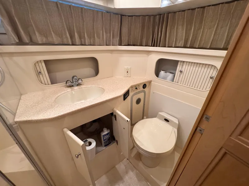 Slide: The Image of 1998 Carver 405 Aft Cabin bathroom with sink, toilet, and storage cabinets. - 23