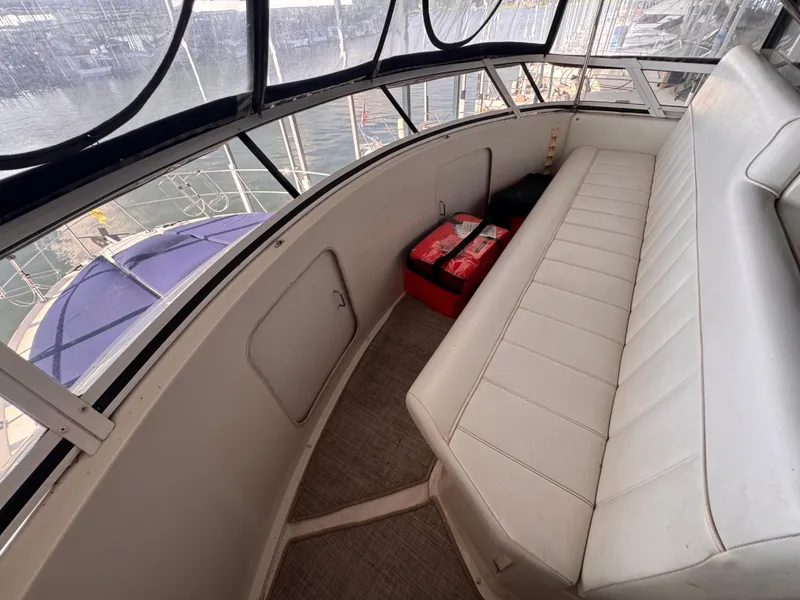 Slide: The Image of 1998 Carver 405 Aft Cabin interior with white seating and marina view. - 26