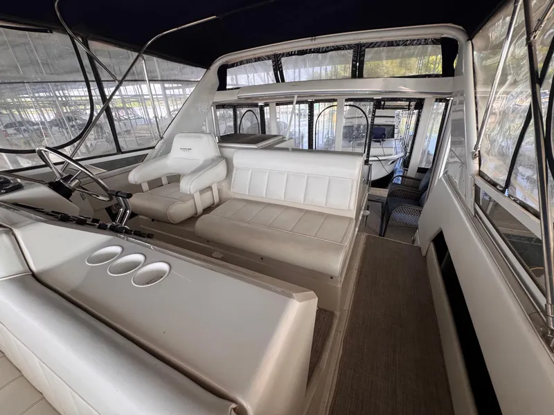 Slide: The Image of 1998 Carver 405 Aft Cabin interior with white seating and steering area. - 27