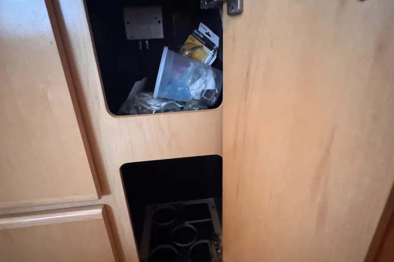 Slide: The Image of Open cabinet on 1998 Carver 405 Aft Cabin boat, showing storage compartments and miscellaneous items. - 30