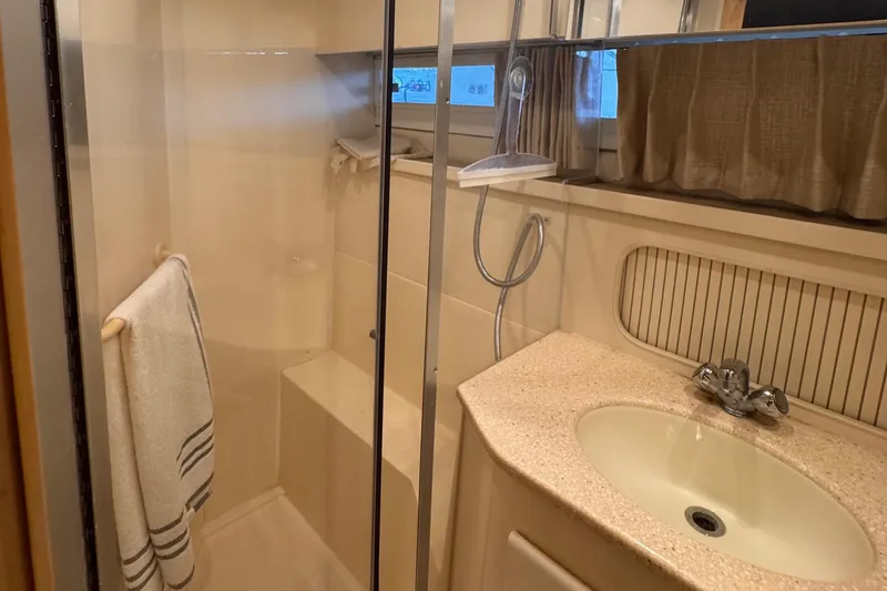 Slide: The Image of 1998 Carver 405 Aft Cabin bathroom with shower, sink, and towel rack. - 35