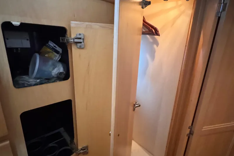 Slide: The Image of 1998 Carver 405 Aft Cabin interior closet with wooden hangers and storage compartments. - 36