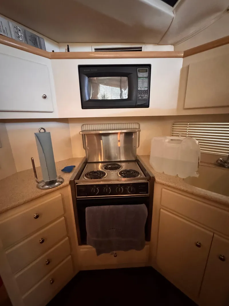 Slide: The Image of Compact kitchen in 1998 Carver 405 Aft Cabin with stove, microwave, and storage cabinets. - 5