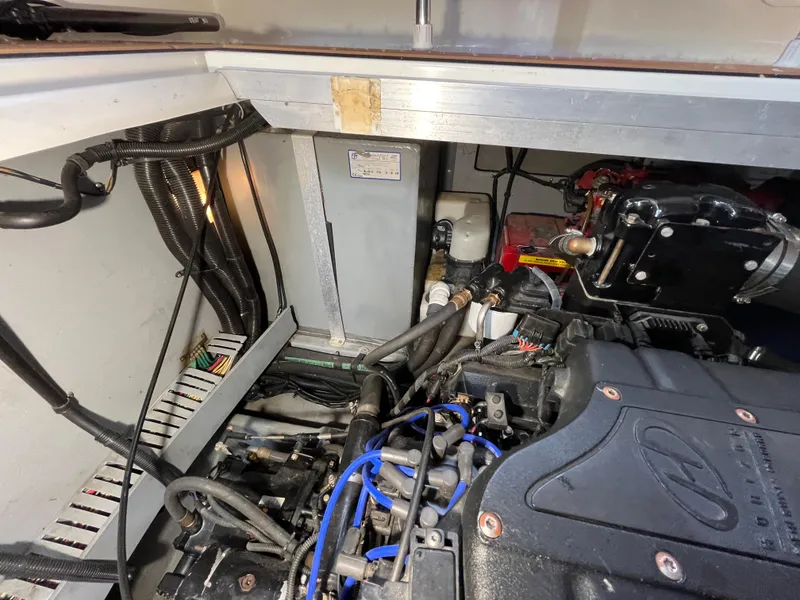 Slide: The Image of Engine compartment of a 1999 Sea Ray 400 Sundancer boat, showcasing mechanical components. - 10