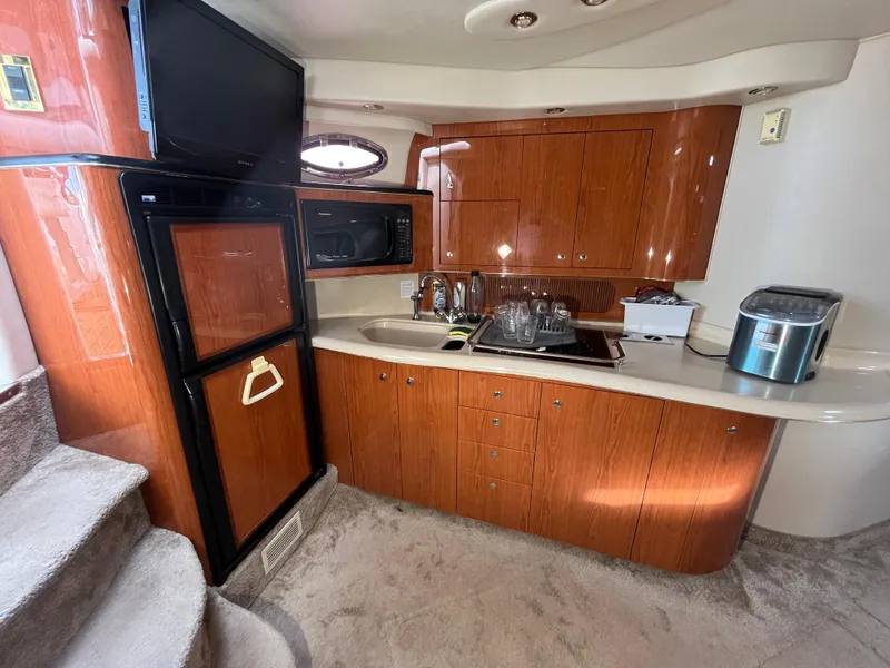 Slide: The Image of 1999 Sea Ray 400 Sundancer yacht interior kitchen with wood cabinets and modern appliances. - 14