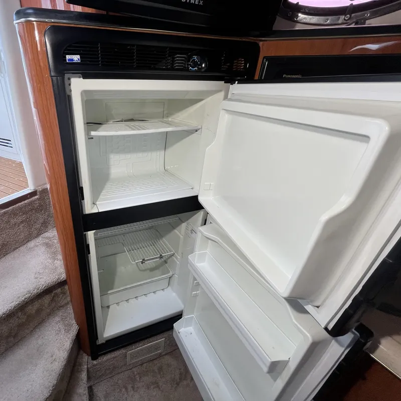 Slide: The Image of Open refrigerator inside 1999 Sea Ray 400 Sundancer yacht, showing shelves and compartments. - 15