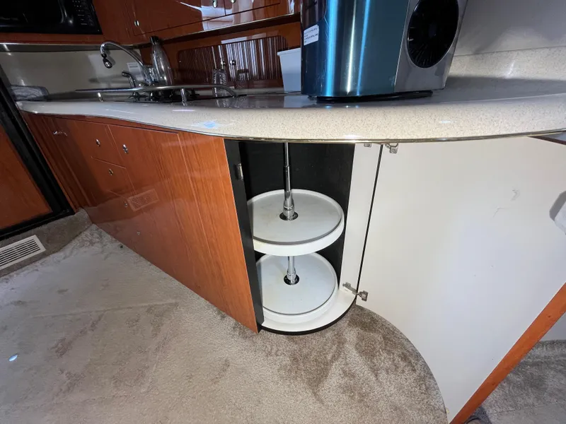 Slide: The Image of 1999 Sea Ray 400 Sundancer kitchen with open cabinet and lazy Susan shelves. - 18