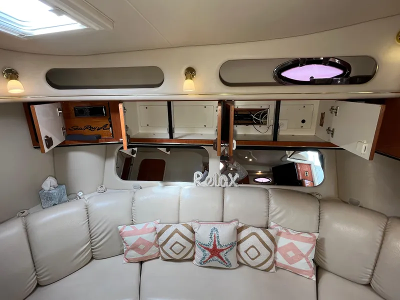 Slide: The Image of Interior of 1999 Sea Ray 400 Sundancer with open cabinets and decorative pillows. - 27