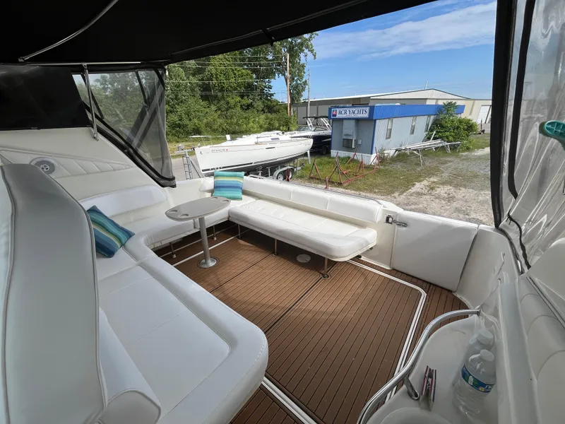 Slide: The Image of 1999 Sea Ray 400 Sundancer yacht interior with white seating and wooden deck. - 35