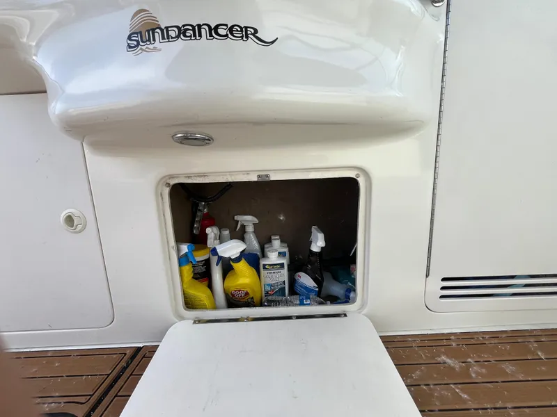 Slide: The Image of Open storage compartment on 1999 Sea Ray 400 Sundancer with cleaning supplies inside. - 39