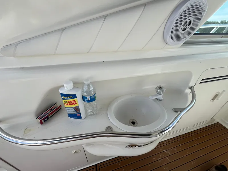 Slide: The Image of 1999 Sea Ray 400 Sundancer sink area with deck cleaner and water bottle. - 40