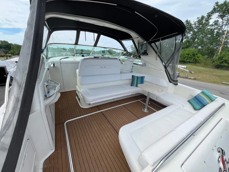 Slide: The Image of 1999 Sea Ray 400 Sundancer interior with white seating and wood flooring. - 43
