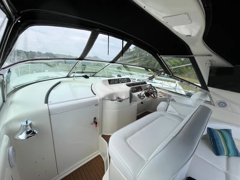 Slide: The Image of 1999 Sea Ray 400 Sundancer cockpit with white seating and modern controls. - 48
