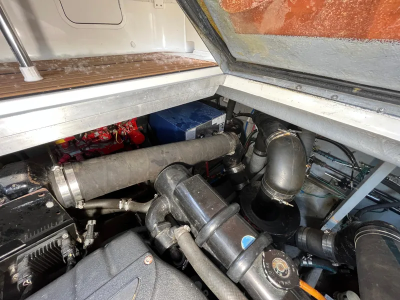 Slide: The Image of Engine compartment of a 1999 Sea Ray 400 Sundancer, showcasing mechanical components and piping. - 8