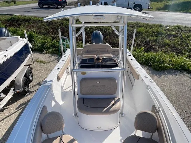 Slide: The Image of 2020 Sportsman 221 Heritage boat with T-top and seating, parked on a sunny day. - 4