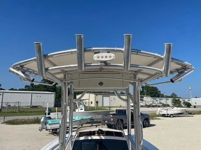 Slide: The Image of 2020 Sportsman 221 Heritage boat with T-top and rod holders in a marina setting. - 9