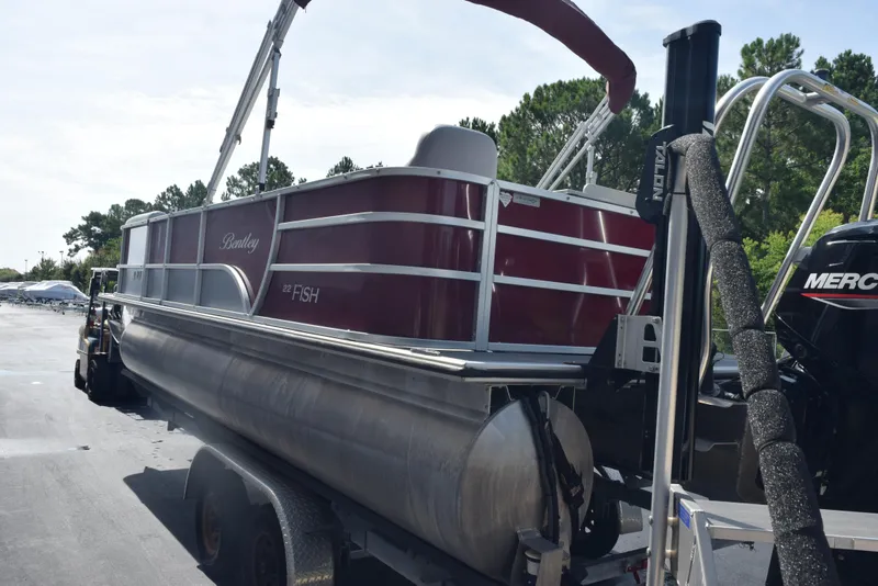 Slide: The Image of 2022 Bentley Pontoons 220 Fish N Cruise on trailer, red exterior, parked outdoors. - 6