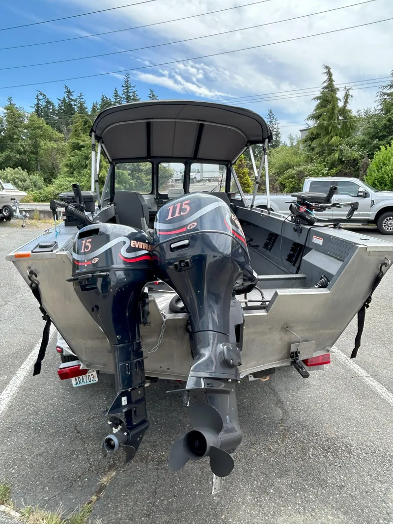 Slide: The Image of 1999 Hewescraft Sea Runner 179 with dual outboard motors in a parking lot. - 4