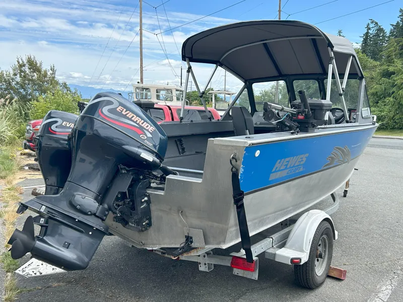 Slide: The Image of 1999 Hewescraft Sea Runner 179 boat with Evinrude motors on a trailer. - 5