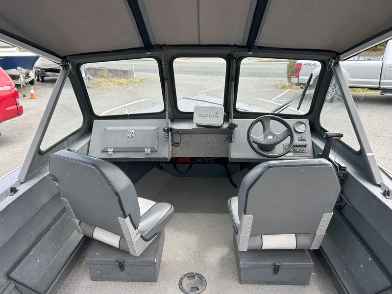 Slide: The Image of Interior of a 1999 Hewescraft Sea Runner 179 boat with steering wheel and seats. - 9