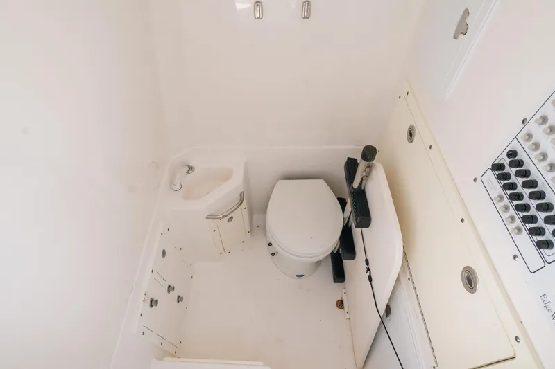 Slide: The Image of Compact bathroom in 2017 Edgewater 318CC boat with toilet, sink, and storage. - 2