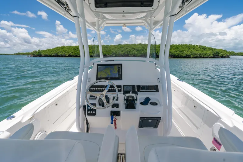 Slide: The Image of 2017 Edgewater 318CC boat on water, featuring spacious deck and clear blue sky. - 5