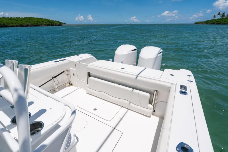 Slide: The Image of 2017 Edgewater 318CC boat on calm waters, featuring dual engines and spacious deck. - 9