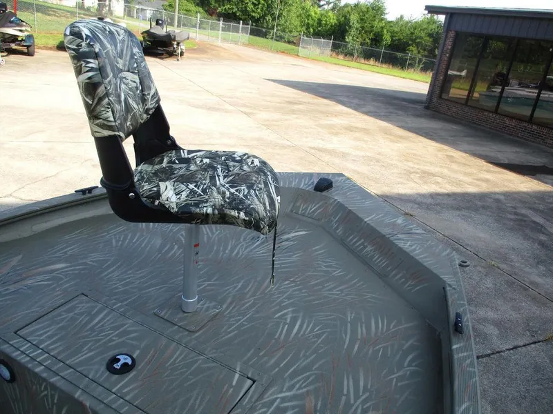 Slide: The Image of 2025 Tracker GRIZZLY® 1654 T Sportsman boat with camo seat on a concrete lot. - 7